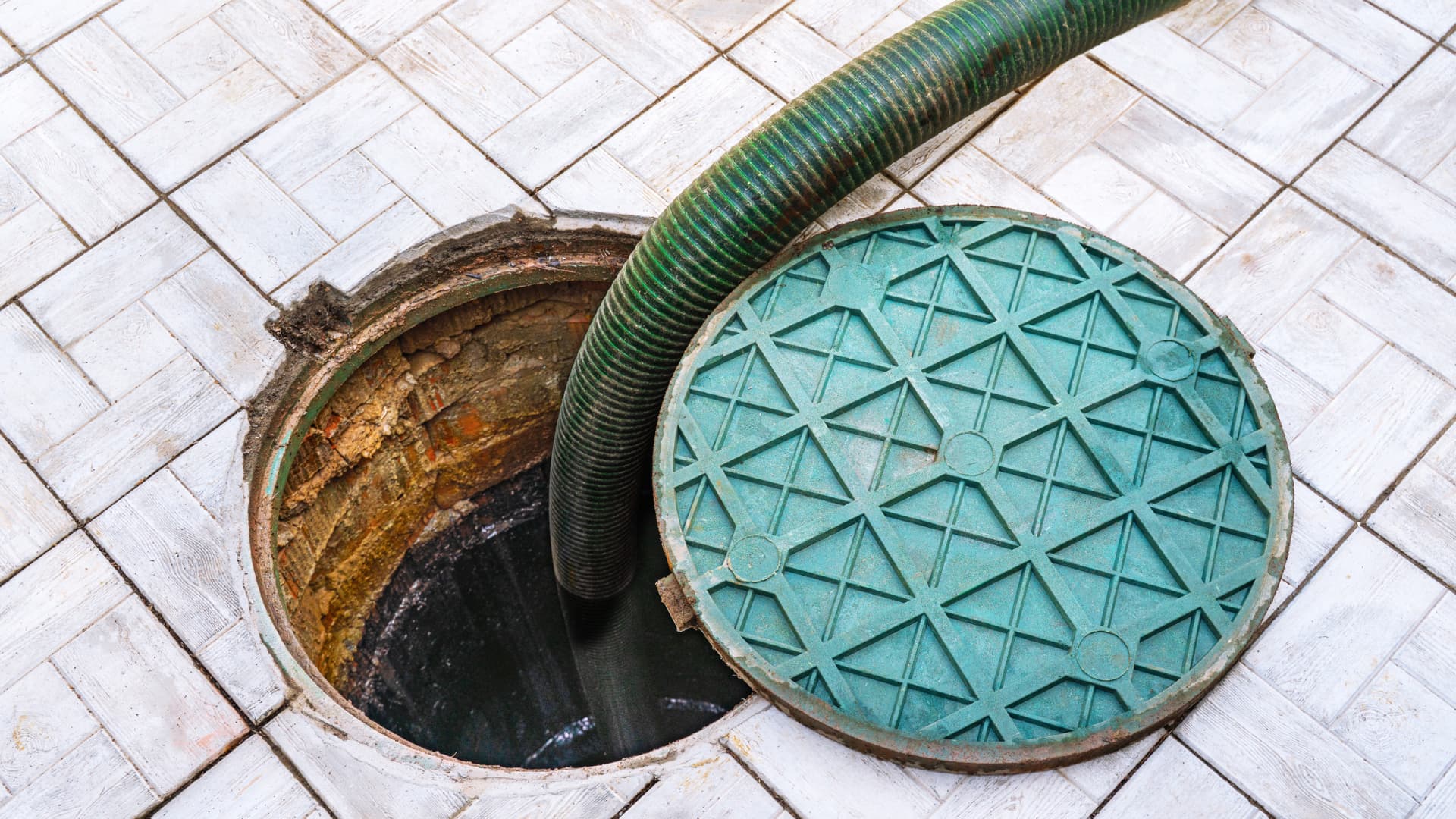 Suction hose lowered into an open storage tank access point